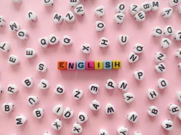 the word english made of beads with letters lying on pink background